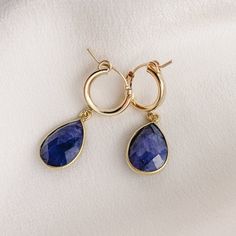 Simple and sweet, these hoop earrings feature small pear-shaped gemstone charms that are faceted on both sides. We've got gemstones for every month of the year. -- charms: 18mm 14k Gold Filled hoop diameter: 13mm secure latch back closure bezel frame: 22k gold plated sterling silver available gemstones: 12 hydrothermal quartz stones Note: moonstone - natural gemstone Everyday Teardrop Huggie Earrings, Gold Faceted Teardrop Hoop Earrings, Yellow Gold Teardrop Earrings With Charms, Fine Jewelry Hypoallergenic Teardrop Hoop Earrings, Fine Jewelry Teardrop Pendant Earrings As Gift, Hypoallergenic Teardrop Huggie Earrings Fine Jewelry, Hypoallergenic Teardrop Hoop Earrings In Fine Jewelry Style, Fine Jewelry Teardrop Earrings For Gift, Hypoallergenic Teardrop Hoop Earrings Fine Jewelry