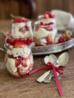 two small jars filled with dessert on top of a wooden table