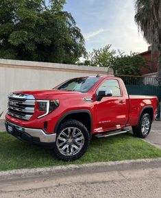 a red truck is parked in the grass