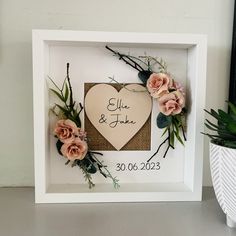 a white frame with flowers and a heart on it