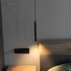 a bed with a wooden headboard and night stand next to the lamp on the wall