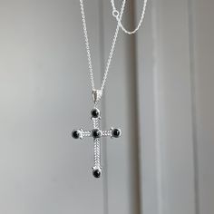 Sterling silver chain necklace with detailed, black onyx cross pendant. Onyx gemstones pop as they are contrasted with polished sterling silver. This necklace would make a beautiful gift! Adjustable length: 16"~ 18" Weight: 4.47g Spring ring clasp (5) 3mm round, genuine black onyx gemstones 1mm cable chain width 925 sterling silver purity Black Sterling Silver Crucifix Jewelry, Spiritual Onyx Cross Jewelry, Spiritual Black Sterling Silver Cross Necklace, Elegant Black Pendant Cross Necklace, Elegant Black Cross Pendant Necklace, Black Sterling Silver Cross Necklace For Gift, Black Sterling Silver Necklace With Silver Clasp, Black Necklace With Sterling Silver Clasp, Elegant Black Crucifix Jewelry