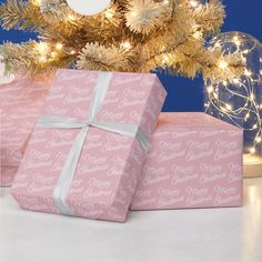 two pink wrapped presents under a christmas tree