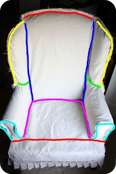 a white chair with multicolored lines on it's back and seat cushion