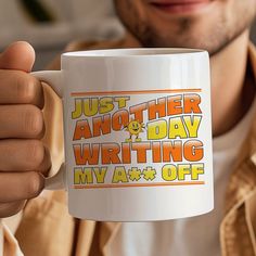 a man holding a coffee mug with writing on it