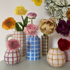 several vases with flowers in them sitting on a table