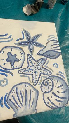 a painting with blue and white designs on it, next to some cookie cutters