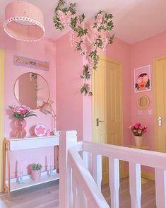 a pink and yellow room with flowers on the wall