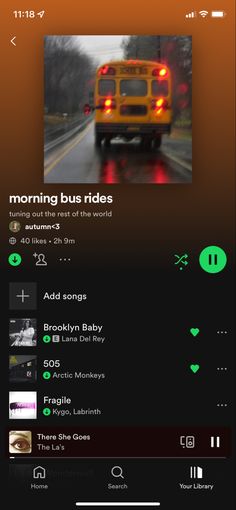 an orange and black bus driving down the road with music player on it's screen