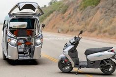 two scooters are parked on the side of the road near a van with its doors open