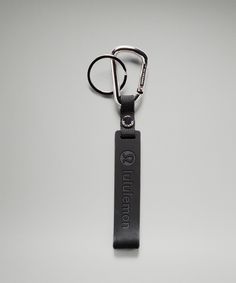 a black keychain with the word queen on it is hanging from a metal hook