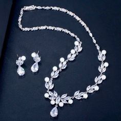 Adorned with iridescent pearls and intricately faceted cubic zirconia that capture the light from every angle with a perfectly translucent appeal, this beautiful bridal jewelry set is rhodium plated for a flawless finish which enhances the intricate detailing and conveys a modern take on old elegance. Necklace: 16.5" (approx. 42cm) long (if you would like it longer, please include a message at the time of order with the preferred length). Earrings: measure 1.2" long (approx. 3cm) and come with s Big Pearl Necklace, Beautiful Bridal Jewelry, Wedding Necklace Set, Pearl Necklace Designs, Bridal Jewelry Set, Pearl Jewelry Wedding, Pearl Necklace Earrings, Big Pearl, Leaf Flower