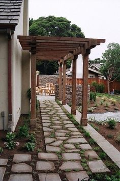 a stone path leading to a house with an attached pergolan