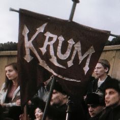 a group of people holding up a krum sign