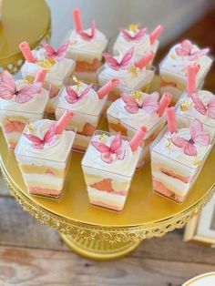 there are many small pieces of cake on the table with pink candles in each piece