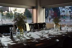 the table is set up for an event with wine glasses and place settings on it