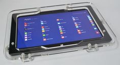 an open tablet computer sitting on top of a clear plastic case with buttons and windows