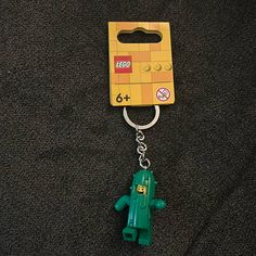 a lego keychain with a green toy figure attached to it's side