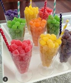 there are many different colored candies in cups