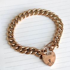 An elegant antique English curb link bracelet, crafted in 9k rosy tinted gold. The chain has plump links closed by a heart shaped padlock clasp, on a safety chain for absolute security. Perfect for layering or wearing as a rich solo statement. The curb chain is a classic, mixing as easily with modern pieces as with antique.  Measuring approximately 9.5 mm or 3/8" wide; the links are hollow, but with a luxurious weight because of their size. A total bracelet length of 7 5/8", the clasp measures 1 Vintage Necklace Antiques, Locket Necklace Vintage, Vintage Jewelry Antique, Bracelet With Heart, Stacked Wedding Rings, Curb Chain Bracelet, Heart Padlocks, Locket Bracelet, Bohemian Bridal