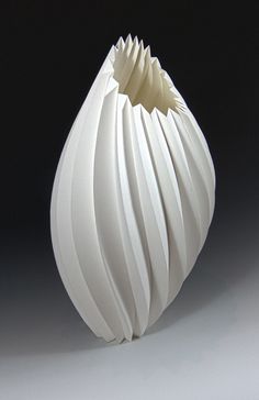 a white vase sitting on top of a table