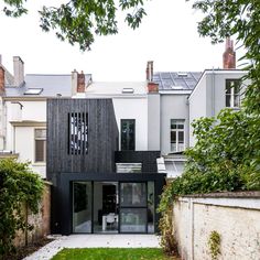 the house is surrounded by many trees and houses with black shutters on each side