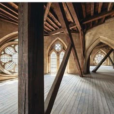 an empty room with wooden floors and arched windows