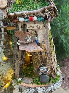 a fairy house made out of tree stumps and rocks with the word camp on it