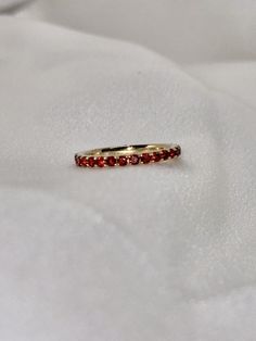 "A timeless and classic design, symbolizing commitment and love. Perfect for everyday wear or dressed up for special occasions. Make a bold statement in our Genuine Garnet Eternity Ring, handcrafted in 14k yellow gold. This ring is not adjustable and is available in US size 7 1/4.  Item Specifications: Materials: 14k Solid Yellow Gold Gemstone: Natural Garnet Total Gold Weight: 2.06 ct. Total Garnet Carat Weight: 1.22 ct.  ★  Each order will be beautifully packaged in a jewelry box and comes with a drawstring pouch that's perfect for travel. LiebeJewelry's products are handcrafted and all materials are genuine and ethically sourced. Our products are made with genuine materials and will not tarnish in the shower or irritate the skin. If you have any additional questions about this ring, jus Oval 14k Gold Eternity Band, Classic Yellow Gold Stackable Halo Rings, Elegant Red Stackable Eternity Band, Classic 14k Gold Half Eternity Stackable Rings, Classic Gemstone Eternity Band, 14k Gold Open Ring Stackable With Half Eternity Detail, Elegant Ruby Gemstone Eternity Band, 14k Gold Open Ring Stackable Half Eternity Rings, Classic Yellow Gold Stackable Rings With Half Eternity