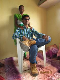 a man sitting on top of a white chair next to a woman