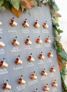 the wedding rings are arranged on a board with greenery and leaves around them for an elegant touch