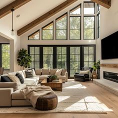 a living room filled with lots of furniture next to a large window covered in windows