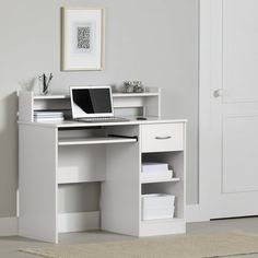 a computer desk with a laptop on top of it in front of a white door