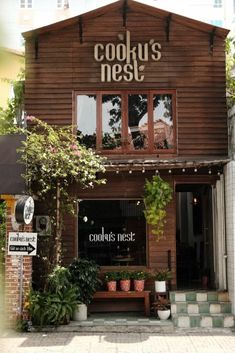 the front of a restaurant with plants growing out of it