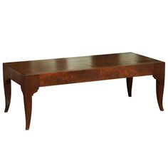 a wooden coffee table with legs and a brown stain on the top, against a white background