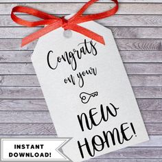 a tag that says congratulations you're home hanging on a wooden background with a red ribbon