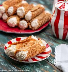 two plates filled with desserts sitting on top of a table next to a red and white striped napkin