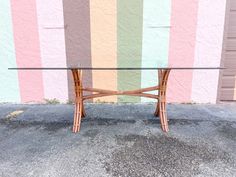 a glass table sitting in front of a multicolored wall with stripes on it