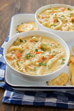 two bowls of soup and crackers on a tray