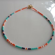 This Bead Necklace consists of Orange seed beads, Turquoise seed beads, White Seed Beads, Navy Blue seed beads. Bead Choker Necklace, I Used Stainless Steel Wire.  A 24-carat gold-plated extension chain, 24-carat gold-plated lobster claw is used. Each length necklace has approximately 1 inch of extension chain. You can also use the Beaded Glass Necklace on your other necklaces. Click on the link to see other Multicolored Necklaces, Beaded Chokers. https://www.etsy.com/shop/dkSeedbead?ref=seller- Bead Seed Necklace, Seed Bead Necklace Ideas Beach, Tiny Beads Necklace, Seed Bead Necklace Color Combos, Beach Seed Bead Necklace, Orange Seed Bead Necklace, Small Bead Necklace Ideas, Summer Necklace Diy, Glass Bead Necklace Ideas