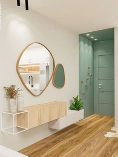 there is a mirror on the wall in this room with wood flooring and white walls