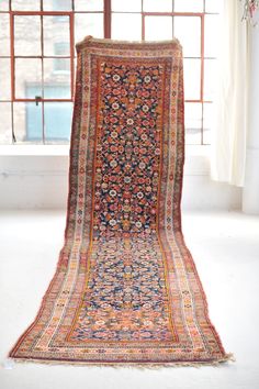 an old rug is sitting in front of a window