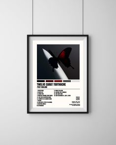 a black and white poster with a red butterfly on it's back side hanging from the wall