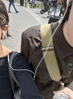 a man with headphones on walking next to a woman