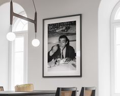 a black and white photo hanging above a dining room table