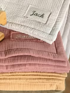 a stack of folded towels and a wooden block on top of each other with the words jack written on them