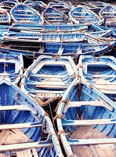 there are many blue boats that are parked together