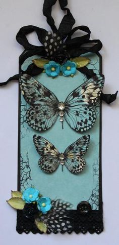 a blue and black card with butterflies on it