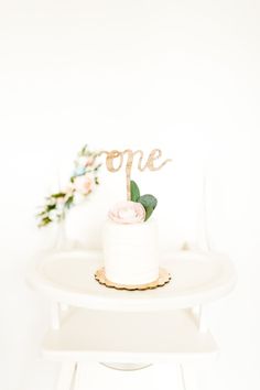 a white cake sitting on top of a table with a wooden sign that says hope