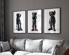 three black and white pictures hang above a couch